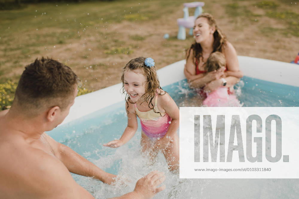 Happy family in an inflatable swimming pool in garden model released Symbolfoto property released SMSF00124