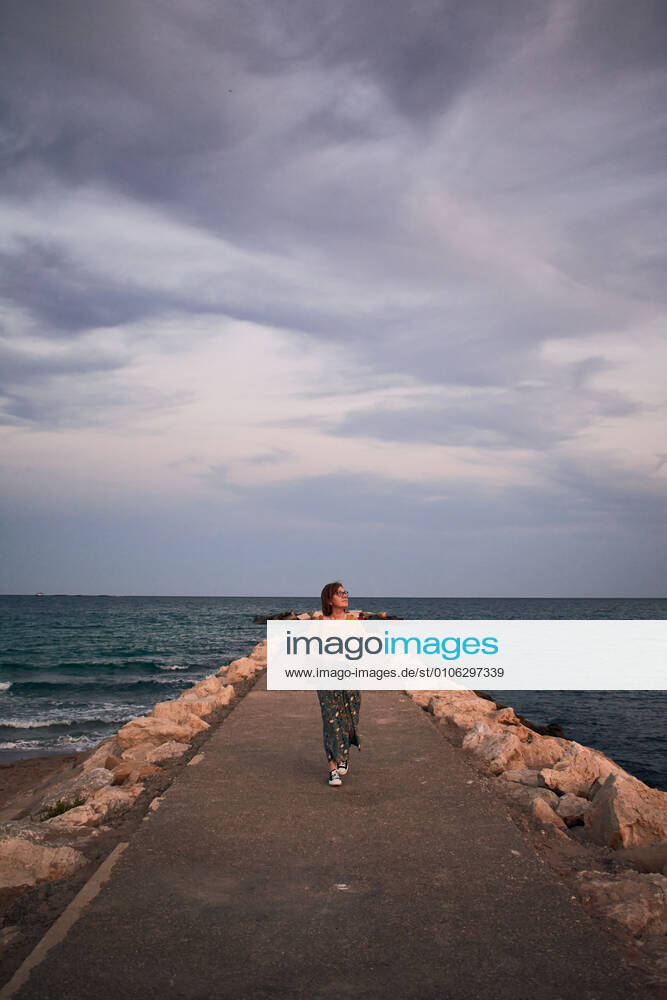 IMAGO Creative: Sommer, Abendspaziergang Middle-aged woman walks on a catwalk on the coast Villajoyosa, Valencian Community, Spain CR_CRBL201023-524985-01 ,model released, Symbolfoto