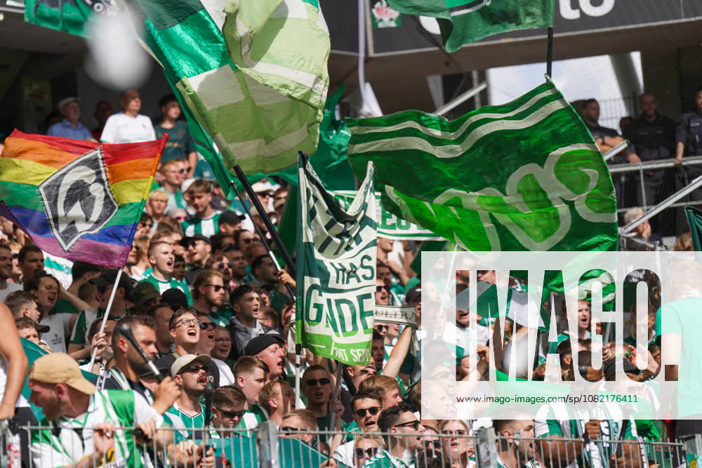 Deutschland: Fussball Bundesliga Saison 2026 - 2027, 1. Spieltag - SC Freiburg vs Werder Bremen - Europa Park Stadion (Freiburg): Fußballfans von Werder Bremen auf der Tribüne im Stadion, dicht gefüllte Fankurve mit zahlreichen grün-weißen Fahnen und Vereinsfarben. Im Vordergrund große Schwenkfahnen, darunter eine Regenbogenfahne mit Werder-Raute. Zuschauer, Fans, Supporter, Fankultur, Fanblock, Tribüne, Fahnenmeer, Regenbogen, Pride, Vielfalt, LGBTQ, Stimmung, Emotionen, Fan-Support, Werder Bremen.