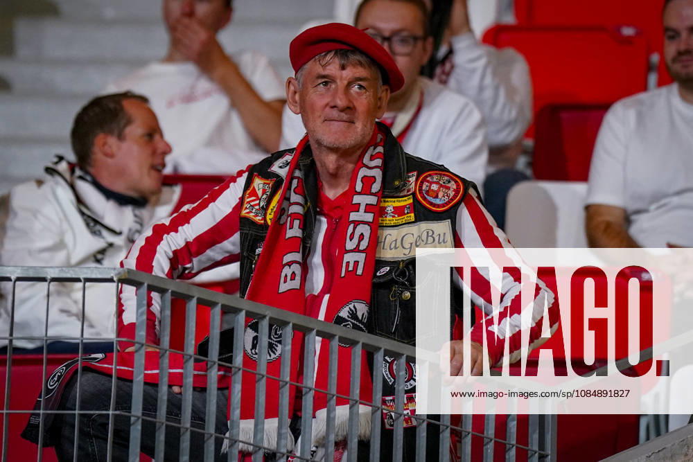 Fussball UEFA Conference League 2026 - 2027, 2. Spieltag - AS Monaco vs SC Freiburg - Stadion Louis II (Monaco): Porträt eines Fans des SC Freiburg auf der Tribüne mit roter Baskenmütze, Fanschal, Fanweste und zahlreichen Fanaufnähern. Freiburg-Fan, Fussballfan, Anhänger, Auswärtsfan, Fankultur, Fanbekleidung, Vereinsfarben, Fanartikel, Fanaccessoires, Zuschauer, Stadion, Tribüne, Europapokal, internationale Fussballspiele, Fanporträt.
