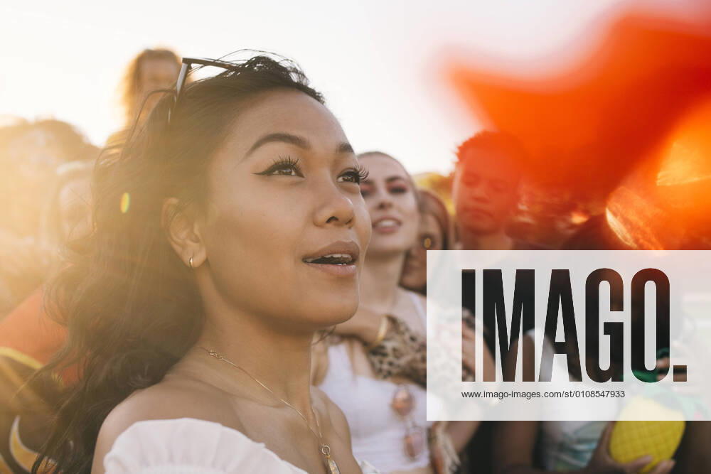 IMAGO Creative: Ruhe im Chaos Smiling woman in crowd enjoying at music festival , model released