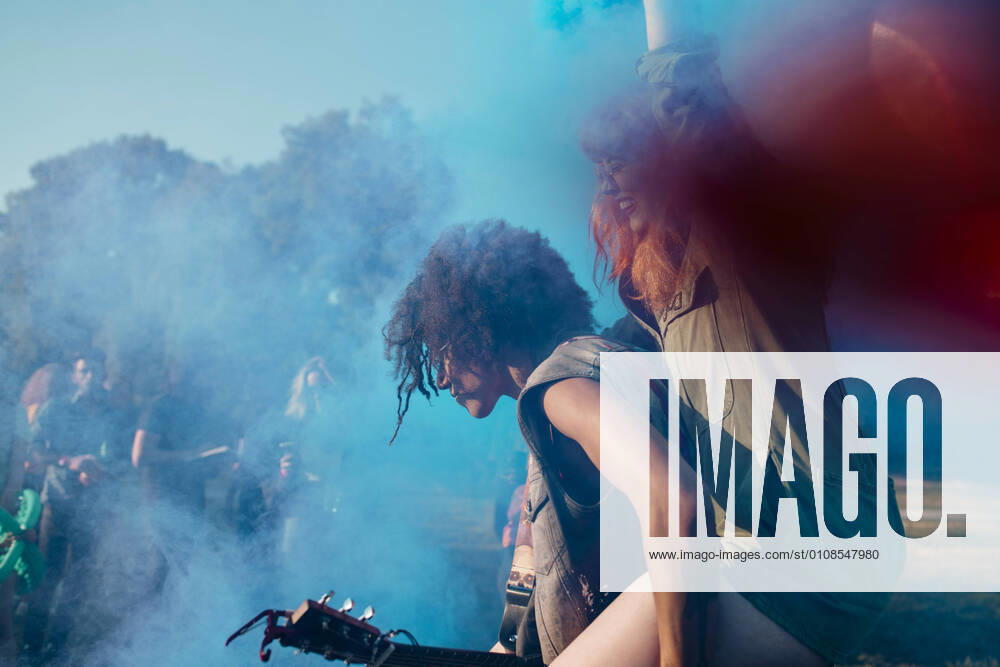 Man piggyback amidst blue powder paint while celebrating Holi , model released