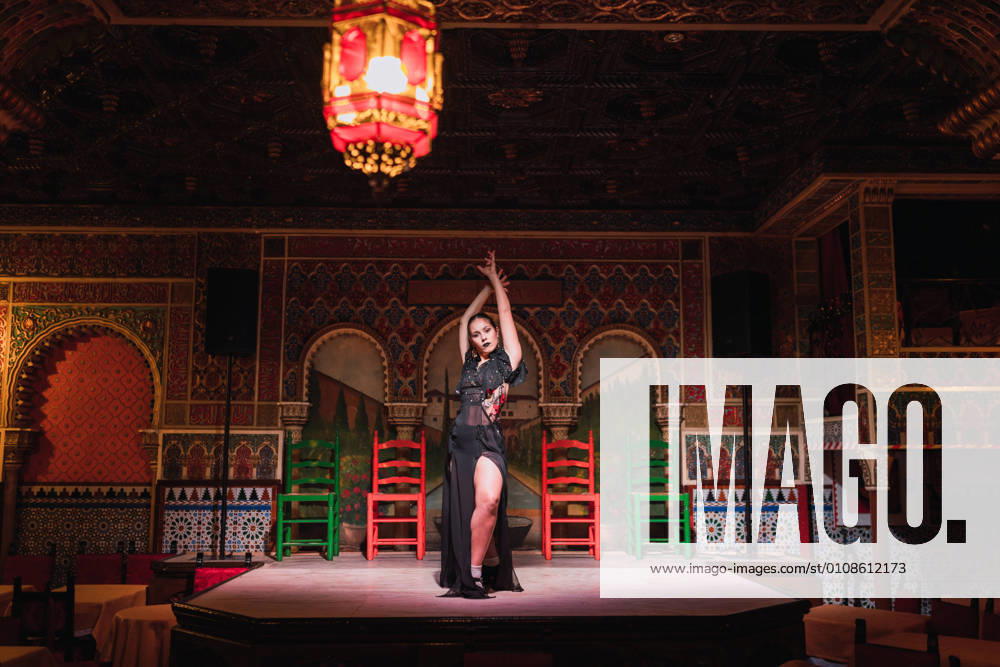 Young lady in dress dancing flamenco on scene in luxury oriental room decorated by mosaic, Model released, Property released