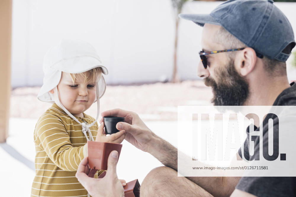 Bearded man playing with son in patio during vacation on sunny day model released Symbolfoto property released ACTF00135