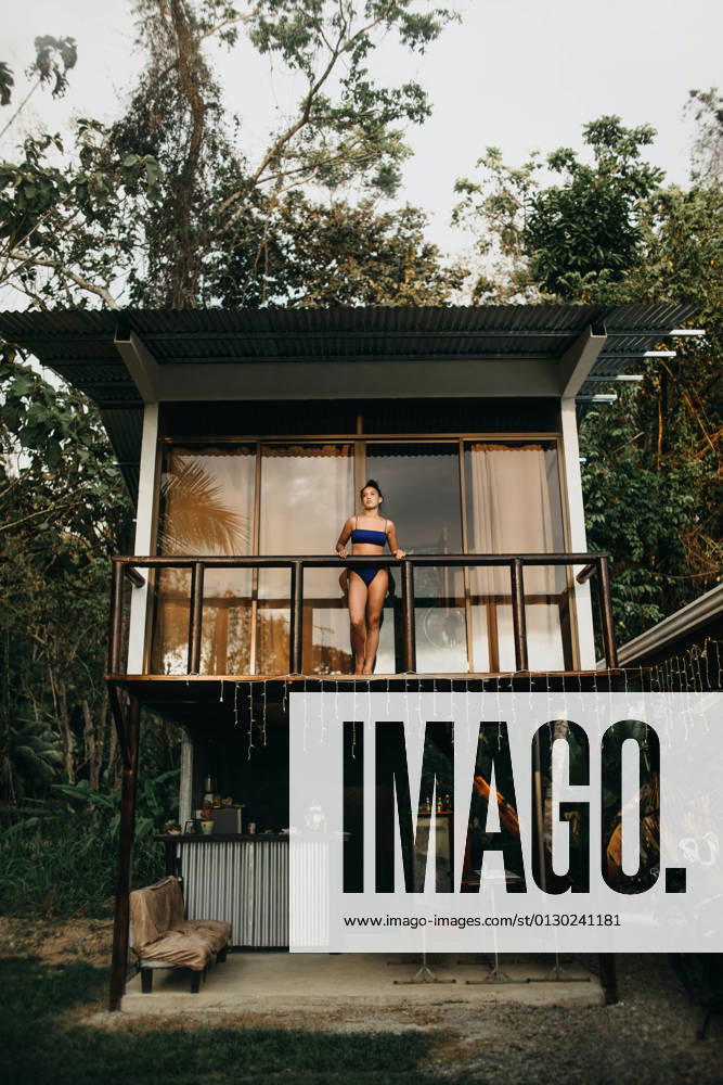 From below full body of young long haired female traveler in stylish swimwear standing on balcony of beach house located near green trees in summer day in Uvita town in Costa Rica, Model released CamilleGirard_CostaRicaTravel_73.jpg
