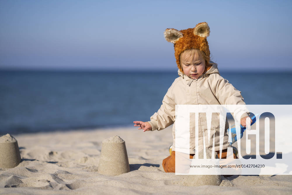 Girl making sandcastle at beach on sunny day model released, SSGF00209