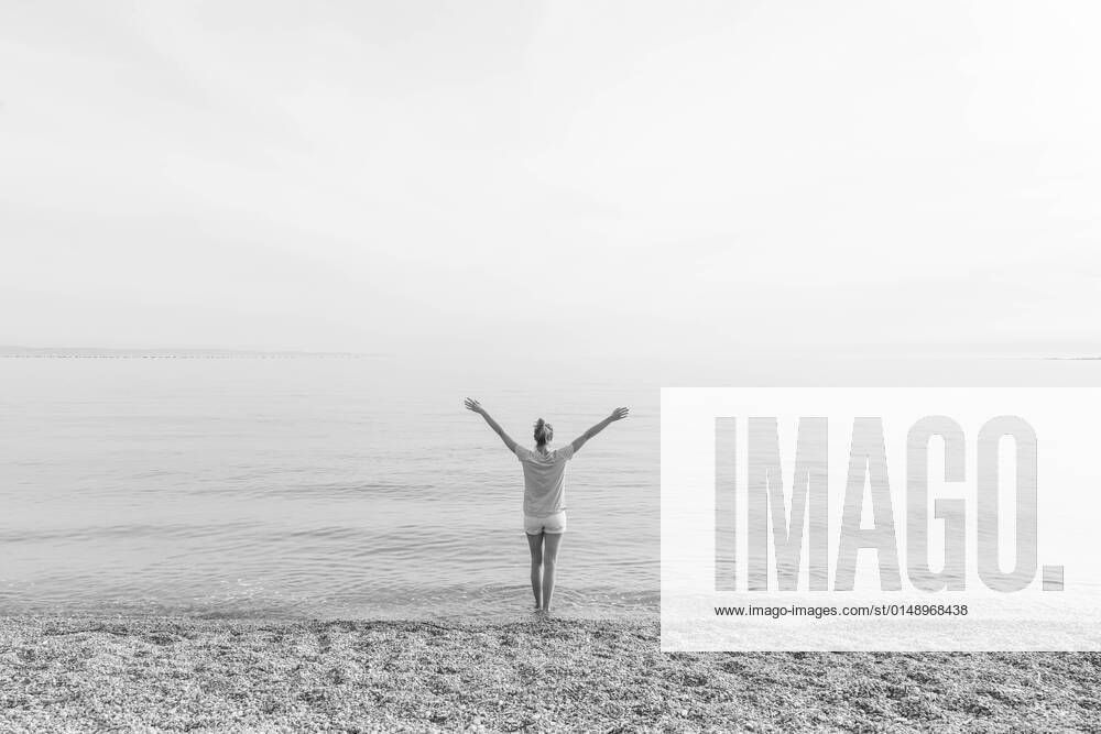 IMAGO Creative: 2022 Favoriten IMAGO Creative: Ende des Sommers Happy Carefree Woman Enjoying Sunset Walk on White Pabbled Beach. Happy Carefree Woman Enjoying Late Afternoon Walk on White Pabbled Beach in Summer.