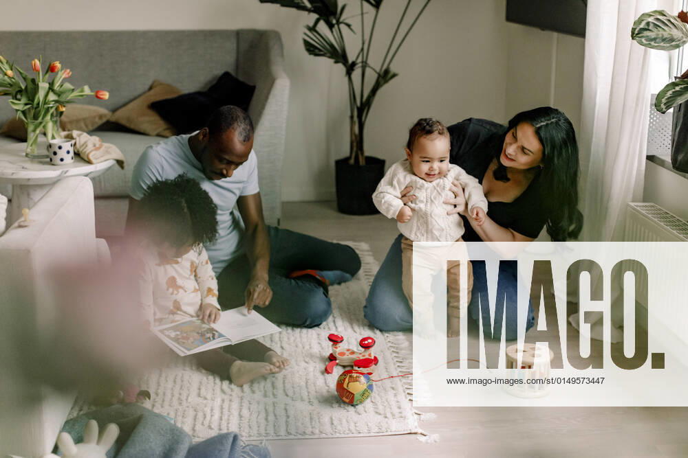 IMAGO Creative: Gesellschaft, Integration Father teaching daughter while mother with son at home Sweden, Stockholm, model released, property released