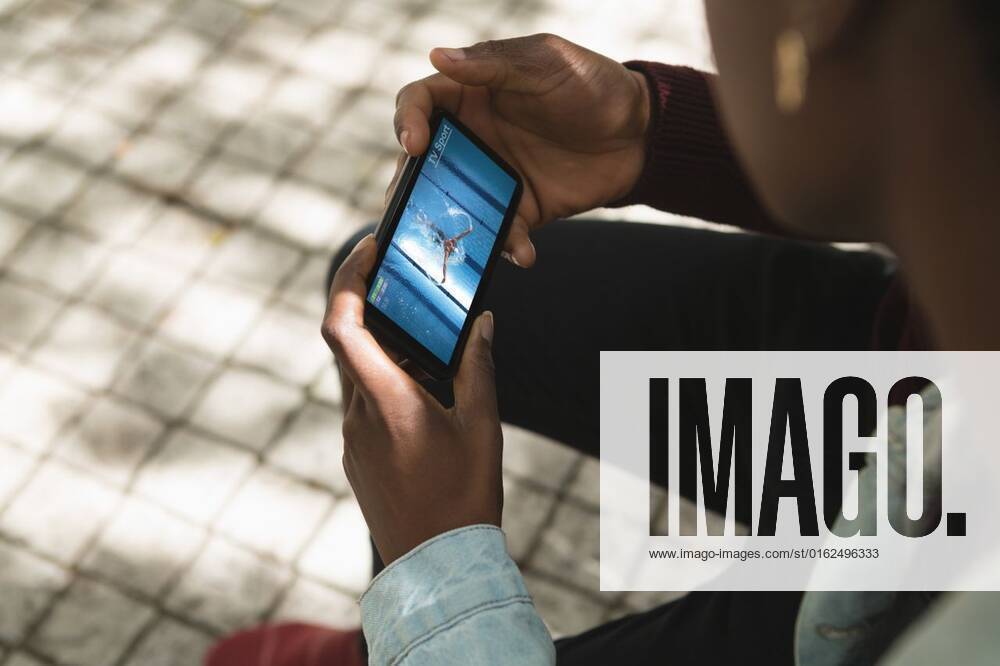 IMAGO Creative: Business, Innovative Technologie-Lösungen African american man in park watching swimming competition on smartphone African american man in park watching swimming competition on smartphone. sports, competition, entertainment and technology concept digital composite image., model released, , property released, Cork, Ireland, 2021-07-09T11:46:04.000Z, 1507275.jpg, people,african american,man,park,watching,swimming,competition,smartphone,sport,entertainment,technology concept,digital composite,composite image,recreation,activity,leisure,active,phone,game,exercise,fitness,mobile,play,athlete,lifestyle,outdoor,training,cellphone,fun,action,player,young,ball,african,american,technology,concept,digital,composite,image Young Adult,Woman,Female,Black,Man,Male,Mid Adult,Caucasian