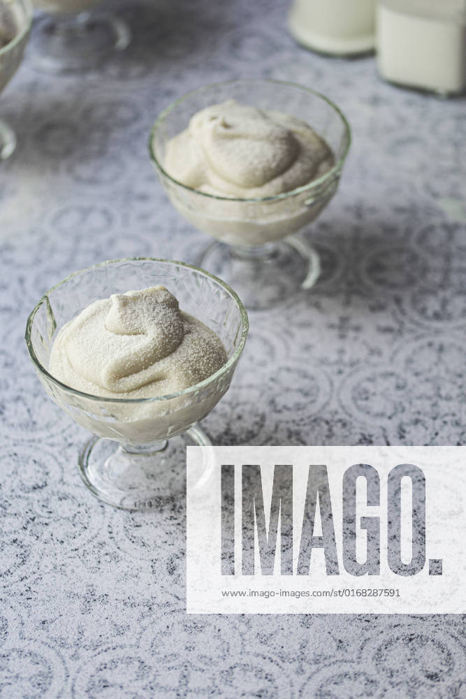 Coconut pudding dessert in a glass bowl against a tile background Coconut pudding dessert in a glass bowl against a tile background