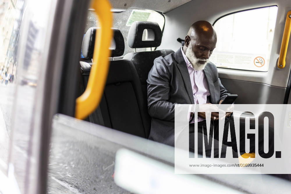 IMAGO Creative: Business, Innovative Technologie-Lösungen Senior businessman using mobile phone in taxi model released Symbolfoto WPEF06486