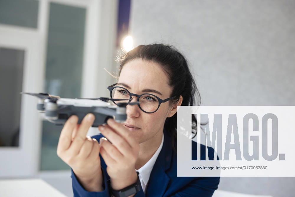 IMAGO Creative: Business, Innovative Technologie-Lösungen Businesswoman with eyeglasses looking at drone model released, Symbolfoto property released, JOSEF11977