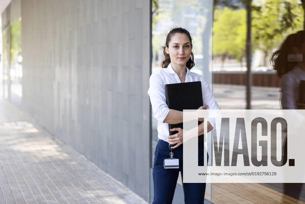 IMAGO Creative: Business, Innovative Technologie-Lösungen Businesswoman with laptop standing by glass at footpath model released, Symbolfoto, WPEF06595