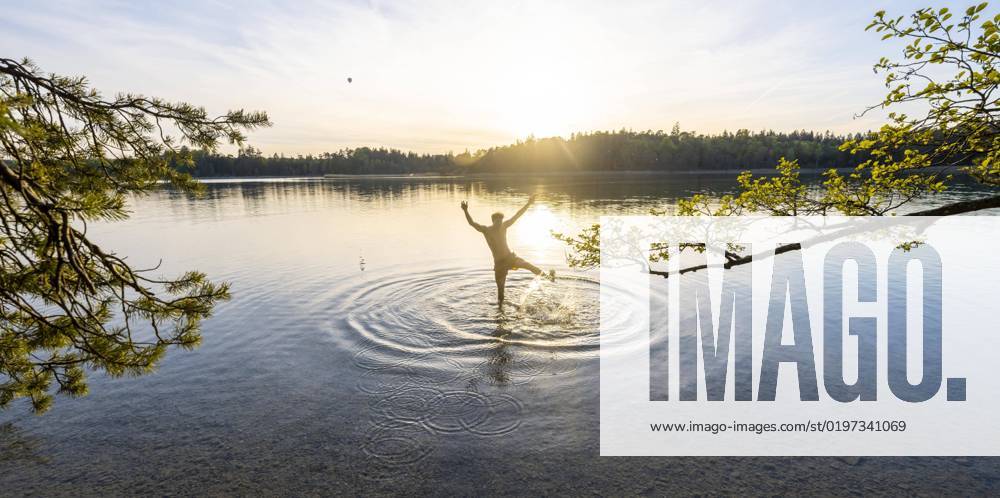 Youngster Man stretches Arms in the Air, at Bathing at Lake, spritzendes Water, Fohnsee, easter lakes, at Iffeldorf, Bavaria, Germany, Europe