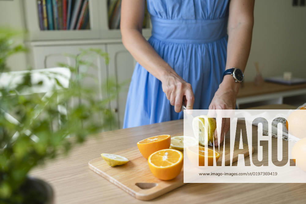 Hands of woman cutting lemons and oranges on table at home model released, Symbolfoto property released, SVKF00784