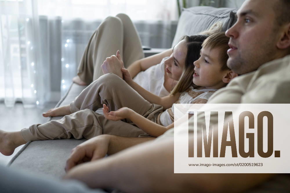 Father and mother watching TV with son at home model released, Symbolfoto property released, ANAF00802