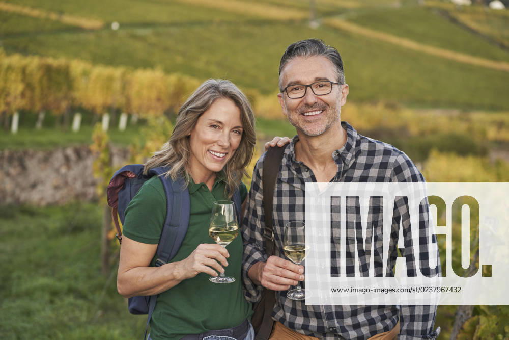 IMAGO Creative, Sommer, Weinfeste und Weinwanderungen Mature couple holding wineglasses on hill model released, Symbolfoto, RORF03377