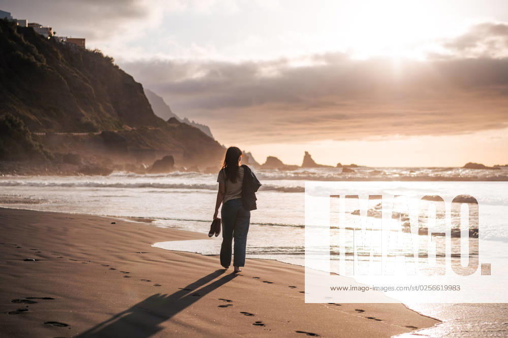 Young woman walking at a black sand beach at sunset Benijo, Canarias, Spain CR_NSRZ230515C5-1189284-01 ,model released, Symbolfoto