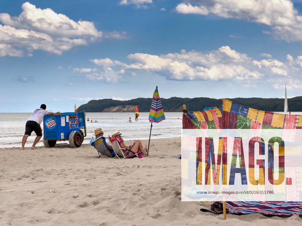 View of the beach of Binz on the island of Rügen in Mecklenburg Vorpommern A man pushes an ice cream cart in front of him A couple sits in their beach chairs Binz is the largest seaside resort on the island of Rügen The municipality belongs