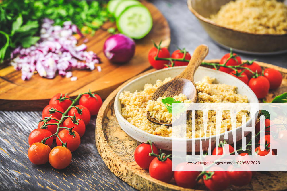 Preparing traditional oriental salad Tabouleh with couscous or bulgur Preparing traditional oriental salad Tabouleh with couscous or bulgur, ingredients on cutting board