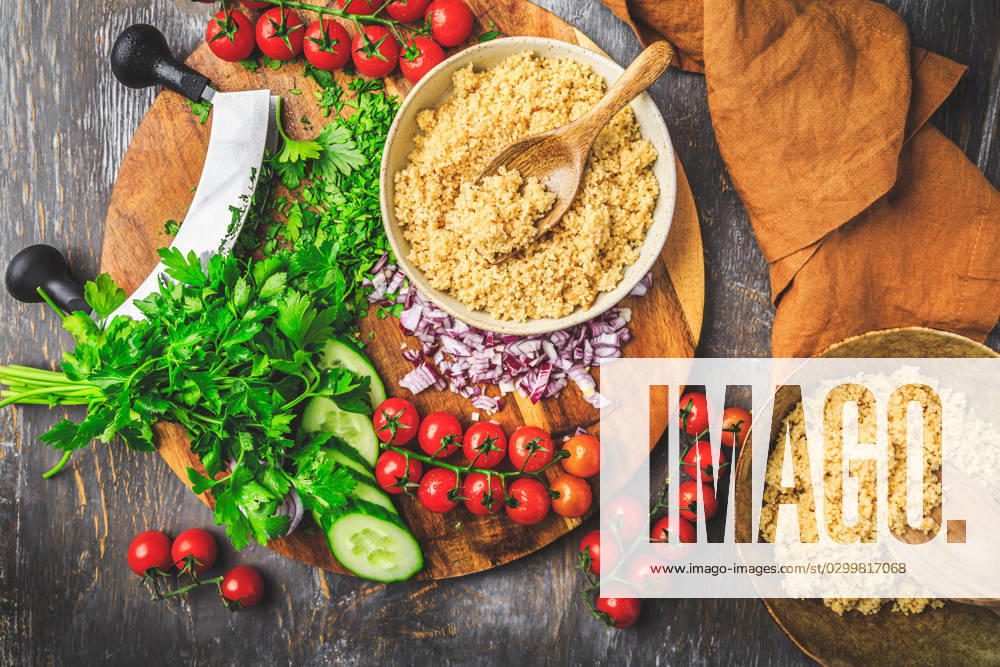 Preparing traditional oriental salad Tabouleh with couscous or bulgur Preparing traditional oriental salad Tabouleh with couscous or bulgur, ingredients on cutting board