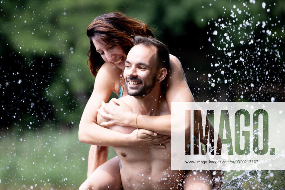 CREATIVE - Paar am See in Berlin Berlin, Deutschland - 25. Juli 2023: (CREATIVE) Ein Mann trägt Huckepack eine Frau (Models) und genießen einen Sommertag an der Krummen Lanke, einem See in Berlin. Berlin