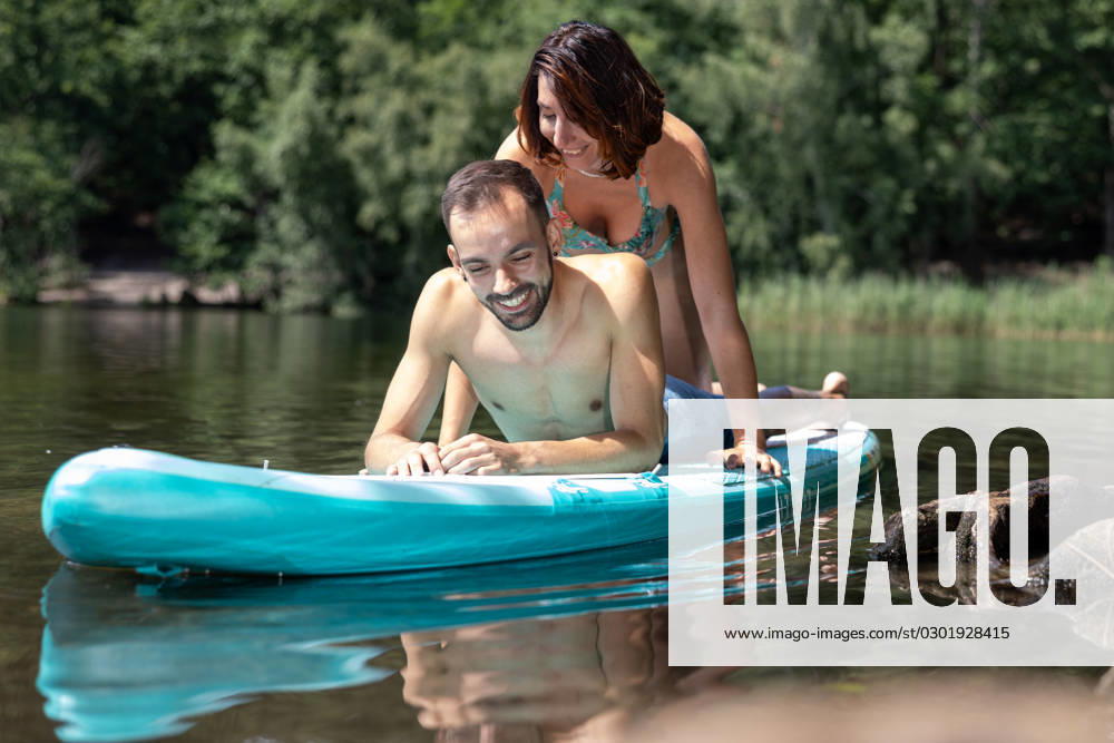 CREATIVE - Paar am See in Berlin Berlin, Deutschland - 25. Juli 2023: (CREATIVE) Ein Mann und eine Frau (Models) genießen auf einem SUP (stand up paddle boat) einen Sommertag an der Krummen Lanke, einem See in Berlin. Berlin