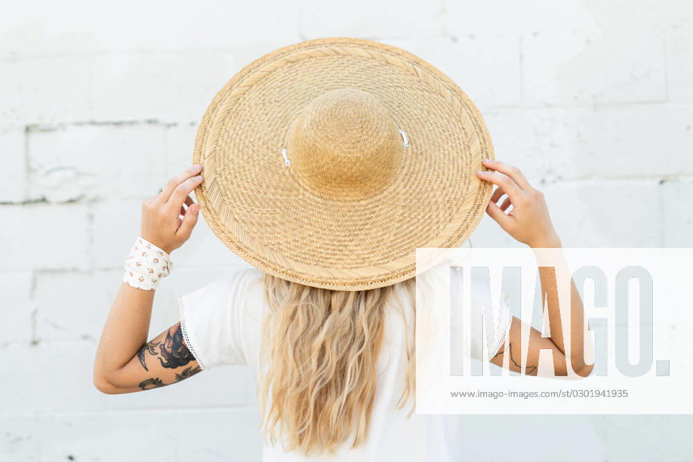 A woman wearing a large wicker hat Iowa City, Iowa, United States CR_VGMI230815-1231693-01 ,model released, Symbolfoto