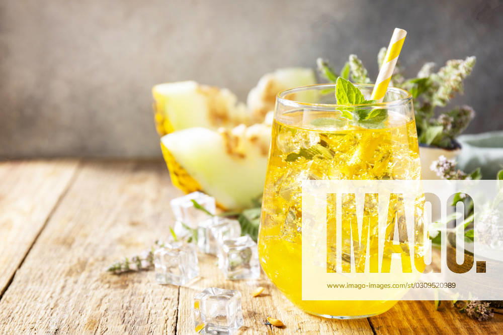 Fresh refreshing fruity summer drink, seasonal beverages. Melon lemonade in glasses with ice and mint on a wooden rustic table. Copy space. Fresh refreshing fruity summer drink, seasonal beverages. Melon lemonade in glasses with ice and mint on a wooden rustic table. Copy space.