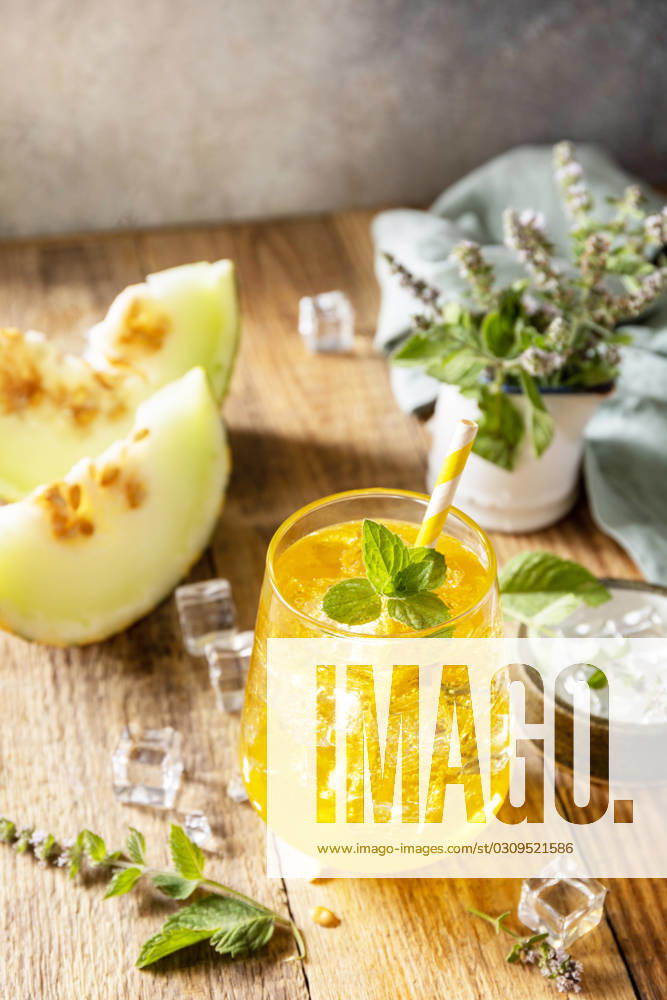 Fresh refreshing fruity summer drink, seasonal beverages. Melon lemonade in glasses with ice and mint on a wooden rustic table. Fresh refreshing fruity summer drink, seasonal beverages. Melon lemonade in glasses with ice and mint on a wooden rustic table.