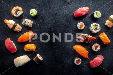 Sushi frame, a flat lay, top shot. Rolls, maki, nigiri on a black slate background, Japanese food. Salmon, eel, shrimp, tuna etc with rice, with a place for text sushi, roll, frame, japanese, food, maki, nigiri, japan, black, background, salmon, sashimi, tuna, restaurant, asian, set, avocado, plate, dinner, seafood, gourmet, eat, raw, eel, rice, shrimp, fish, menu, california, philadelphia, traditional, overhead, above, view, top, shot, flat, lay, flatlay, flat lay, banner, dish, cheese, tobiko, cucumber, meal, lunch, slate, uramaki, whitefish