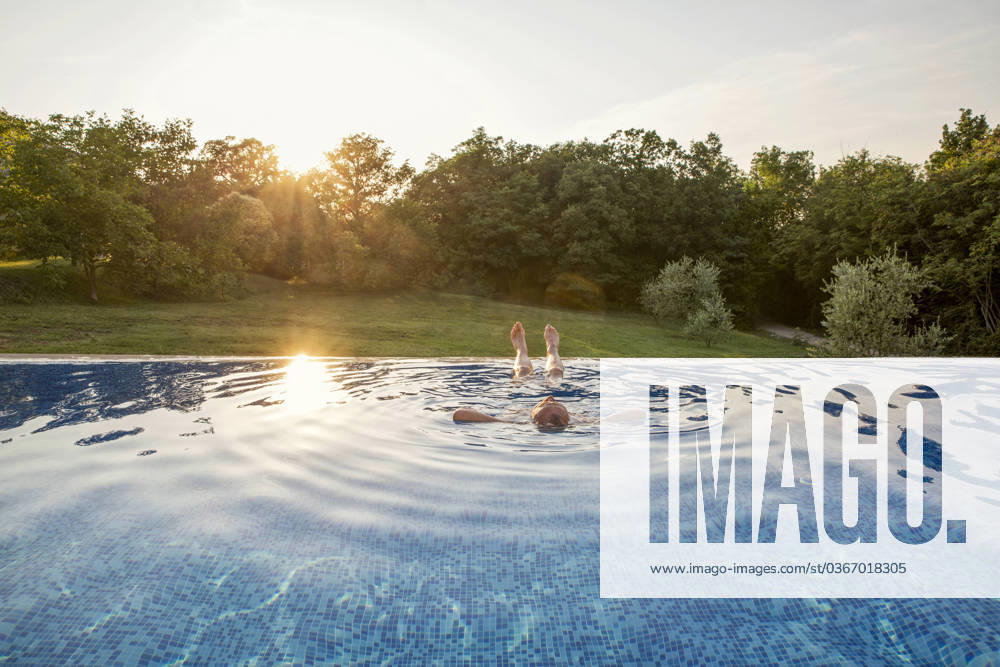 Senior man relaxing in swimming pool at sunset model released, Symbolfoto property released, MAMF02898