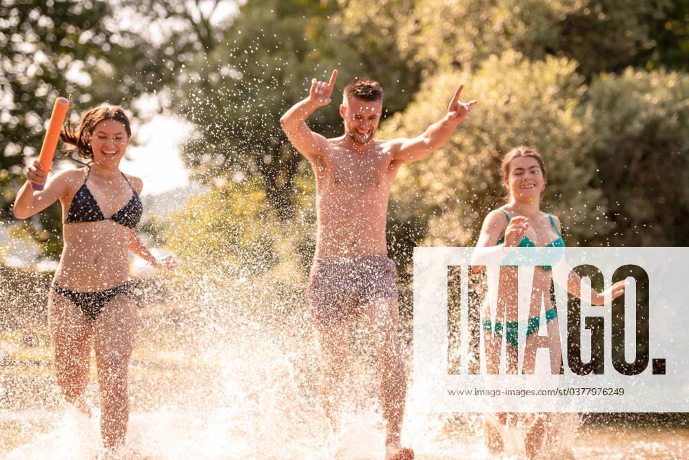 Summer joy friends having fun on river summer joy group of happy friends having fun while running and splashing on river ,model released, Symbolfoto
