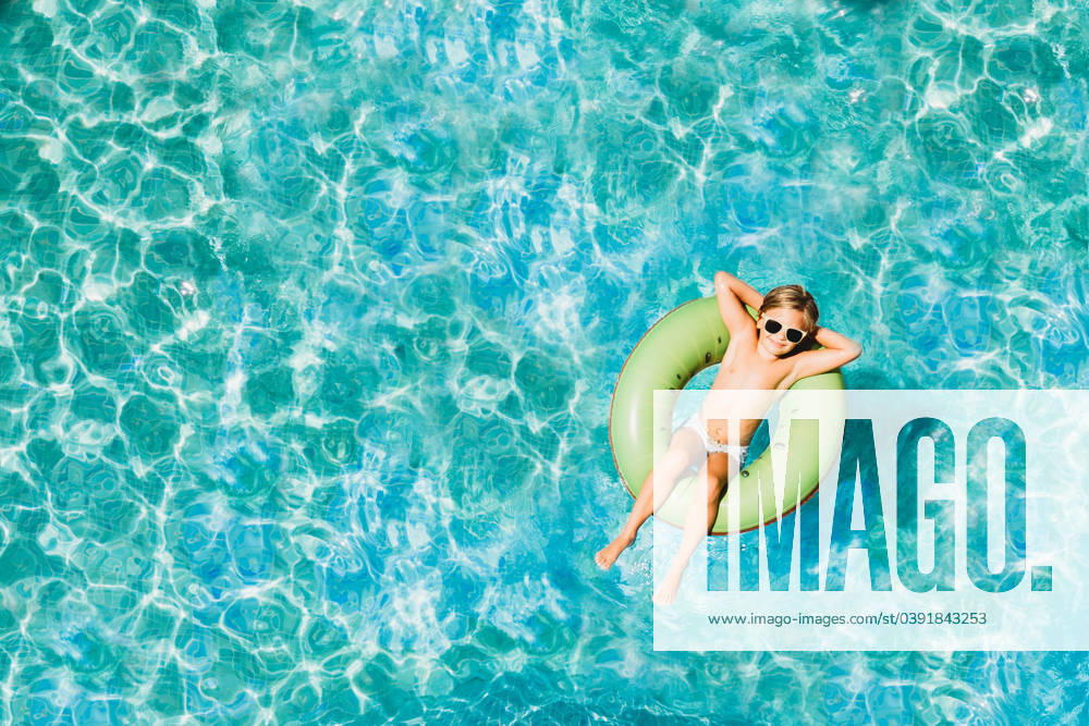Young child floating in pool with floats photo from above with drone Spain, Andalusia, Benalmádena CR_TANI2401238D-1340207-01 ,model released, Symbolfoto