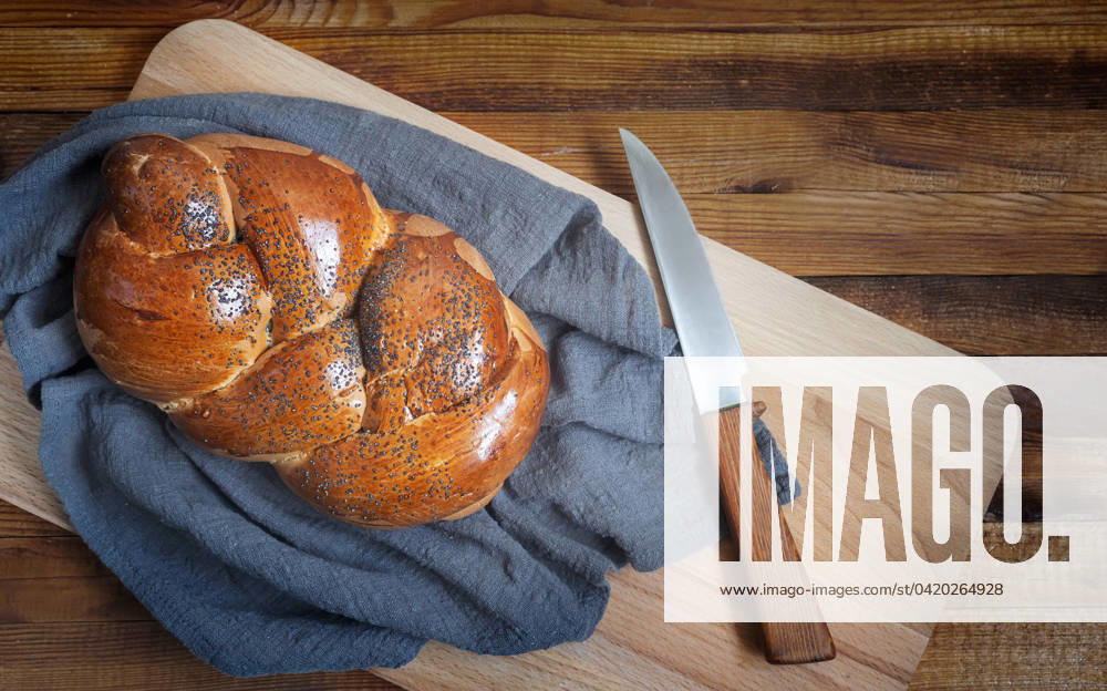 IMAGO Creative: Food, Mohn A loaf of white bread and a knife on the kitchen Board A loaf of white bread with a crisp crust, sprinkled with poppy seeds and a knife on the kitchen Board. Top view, copy space.