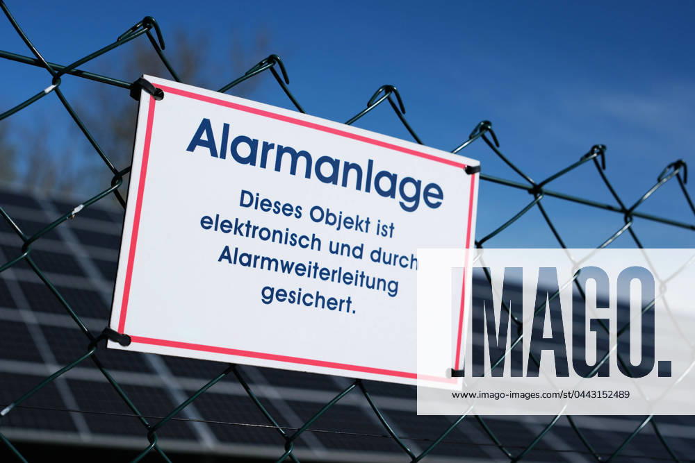 Hinweis auf Sicherung durch eine Alarmanlage am Zaun einer Solaranlage.