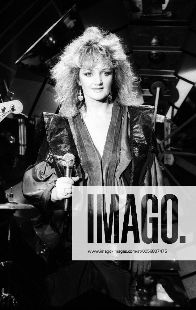 Bonnie Tyler (Sängerin) 01 86 scha Bonnie Tyler im WWF-Club im Januar 1986 Wales walisisch walisische Großbritannien englisch englische Gesang Rock Fernsehen Sendung Show TV Frau female singer english welsh hoch halb lächelnd blond Locken Mikrofon Lederjacke schwarz Bühne Auftritt sw