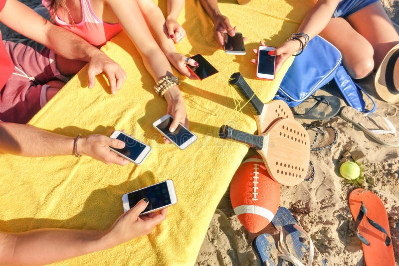 Group of multiracial friends having fun together with smartphone, Best friends having fun together with smartphone - Mixed hands with mobile smart phone in sunny day - Technology concept in summer beach life