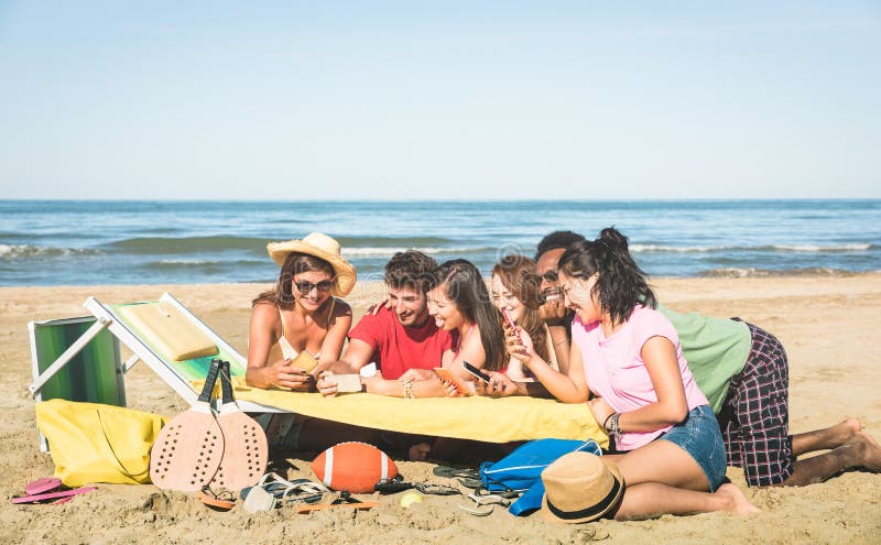 Group of multiracial friends having fun together with smartphone, Multiracial friends having fun together with smartphone - Young people with mobile smart phone in sunny day - Technology concept in summer beach lifestyle