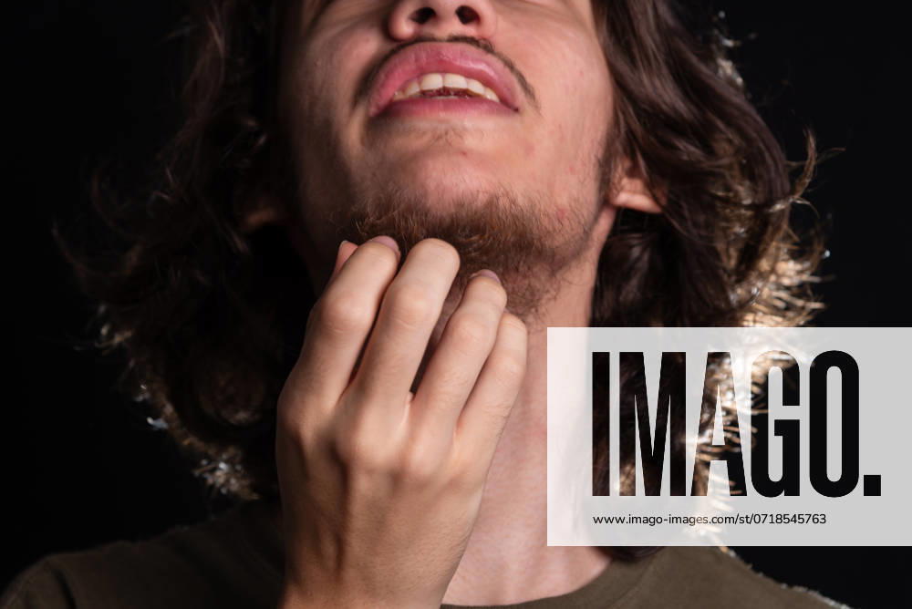 Man scratching his neck with his hand. Skin disease. Irritation, allergy. Isolated on black background. Salvador Bahia Brazil