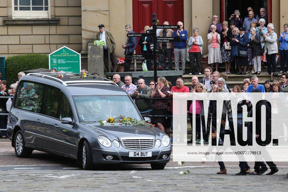 Trauerfeier für Jo Cox in Batley July 15, 2016 - Batley, West Yorkshire, UK - Batley, UK. A family puts down flowers in front of Jo Cox s funeral cortege as it passes through her hometown of Batley, West Yorkshire. The Labour MP was stabbed and shot in the street as she left her constituency surgery last month. Thomas Mair was arrested in connection with the murder and is set to face trial this year. Batley UK - ZUMAl94_