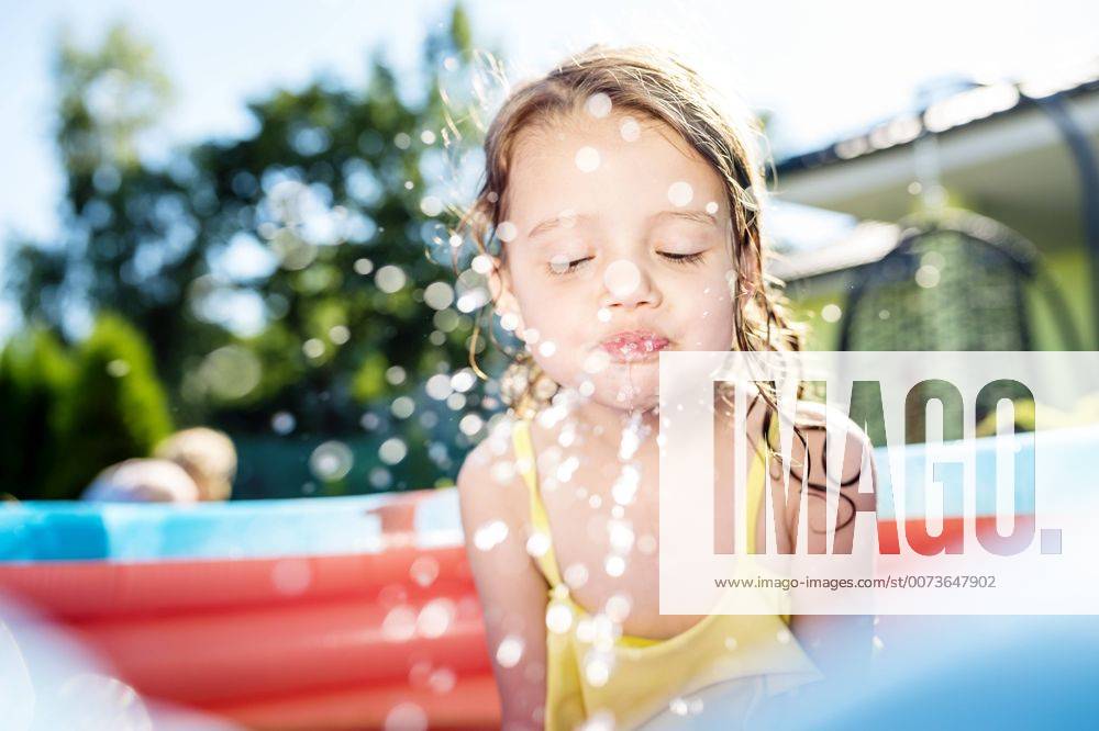 Little girl sitting in paddling pool splashing with water model released Symbolfoto property released HAPF000759