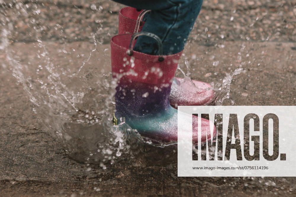Splashing in a buddle in rainbow rainboots Cincinnati, Ohio, United States R_KRHE210921-832852-01 ,model released, Symbolfoto