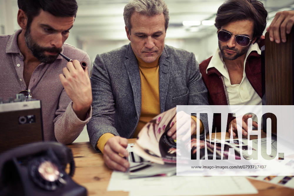 Three designers clad in retro 70s wear working on a project together., model released, , 47261038.jpg, style, business, businessperson, hippie, masculine, vintage, group, groovy, macho, job, working, 70s, seventies, businesspeople, trendy, retro photography, clothing, fashion, vintage photography, retro, designer, three, corporate, young, people, mature, male, adult, men, team, work, inside, person, handsome, desk, creative, caucasian, serious, teamwork, cropped, telephone, smoking, career, brainstorming, hip, colleague, magazine, occupation, manly, middle aged RECORD DATE NOT STATED