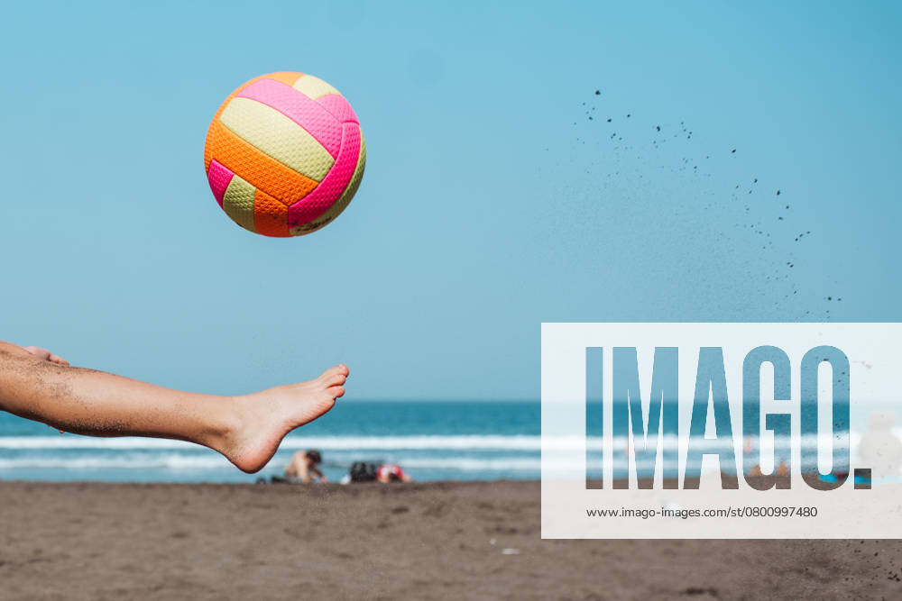 Close up of boy s leg kicking soccer ball on sandy beach, enjoying family vacation. Close up of boy s leg kicking soccer on a sandy beach, enjoying a family vacation. model released