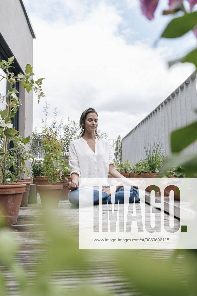 Woman sitting on balcony practicing yoga model released Symbolfoto property released JOSF01579