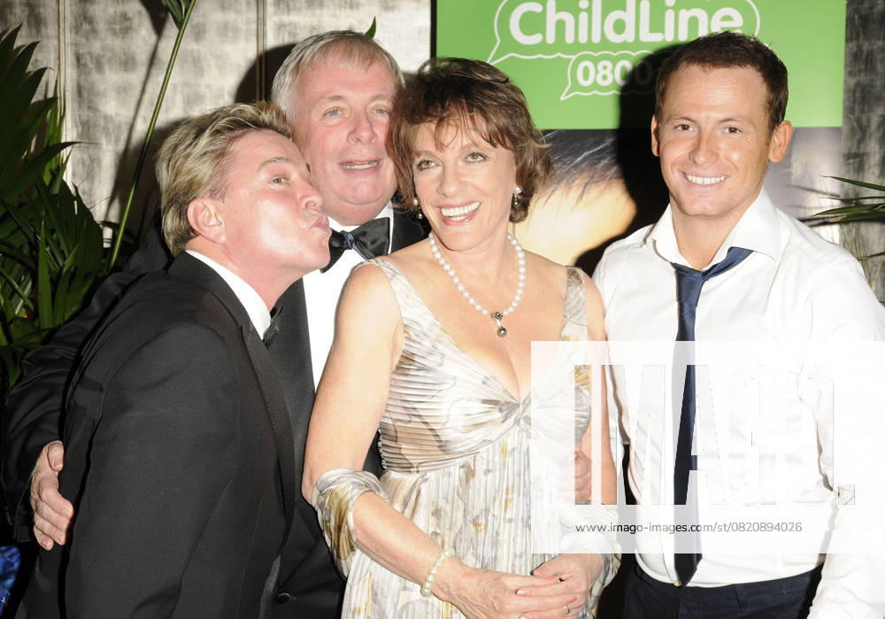 I m A Celebrity Childline Ball DAVID VAN DAY, CHRISTOPHER BIGGINS, ESTHER RANTZEN & JOE SWASH I m A Celebrity Childline Ball held at the Park Lane Hotel, London, England. October 21st 2009 half length white floral print pleated pleats grey gray dress kissing kiss pouting cheek pearl necklace funny profile black suit jacket white shirt CAP CAN Can Nguyen London UK Great Britain