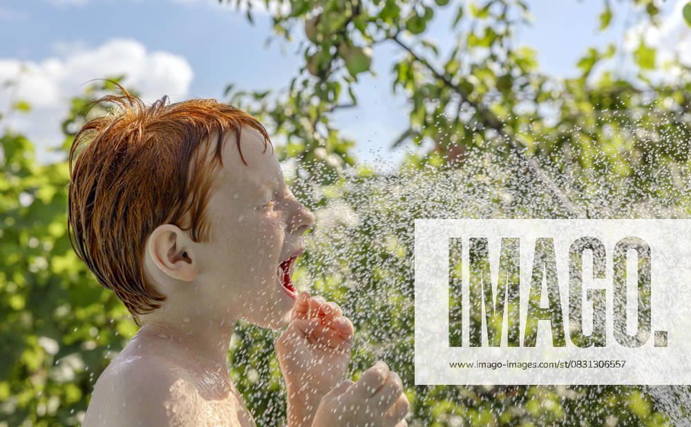 Red-haired child playing and splashing in outdoor pool on a sunny day model released, Symbolfoto, MBLF01008