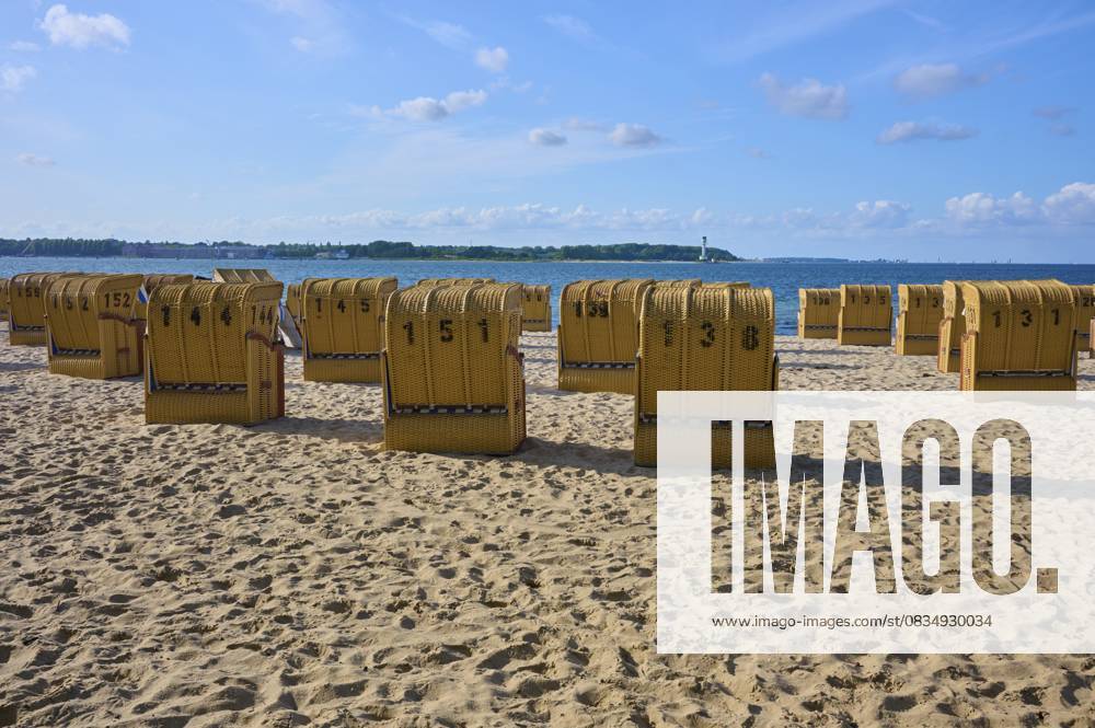 Reihe von nummerierten Strandkörben unter blauem Himmel an einem sonnigen Sandstrand, Heikendorf, Kreis Plön, Kieler Förde, Schleswig-Holstein, Deutschland Row of numbered beach chairs under a blue sky on a sunny sandy beach, Heikendorf, Plön district, Kiel Fjord, Schleswig-Holstein, Germany