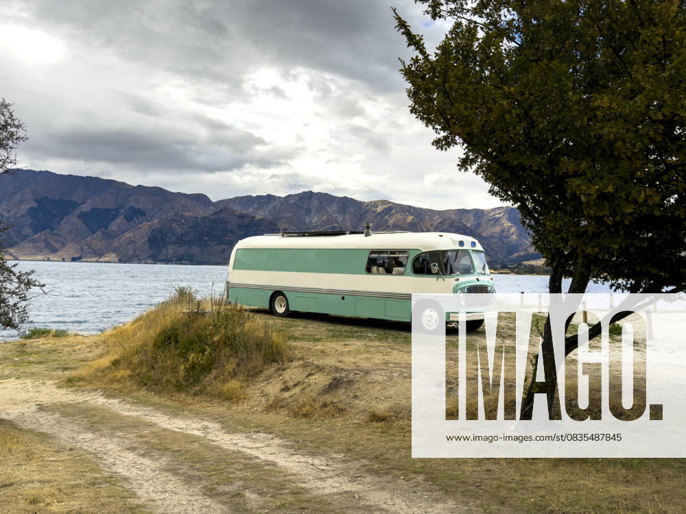 MR_ID31268_22828_AlvaroEsteller.jpg, MR_ID31268_22829_XimenaLozano.jpg A vintage camper van is parked by Lake Wanaka near Roys Peak in New Zealand during autumn. The scenic mountain backdrop and lakeside setting evoke freedom and adventure travel Model Released JuanAizpuru_ID31268_1061759_018